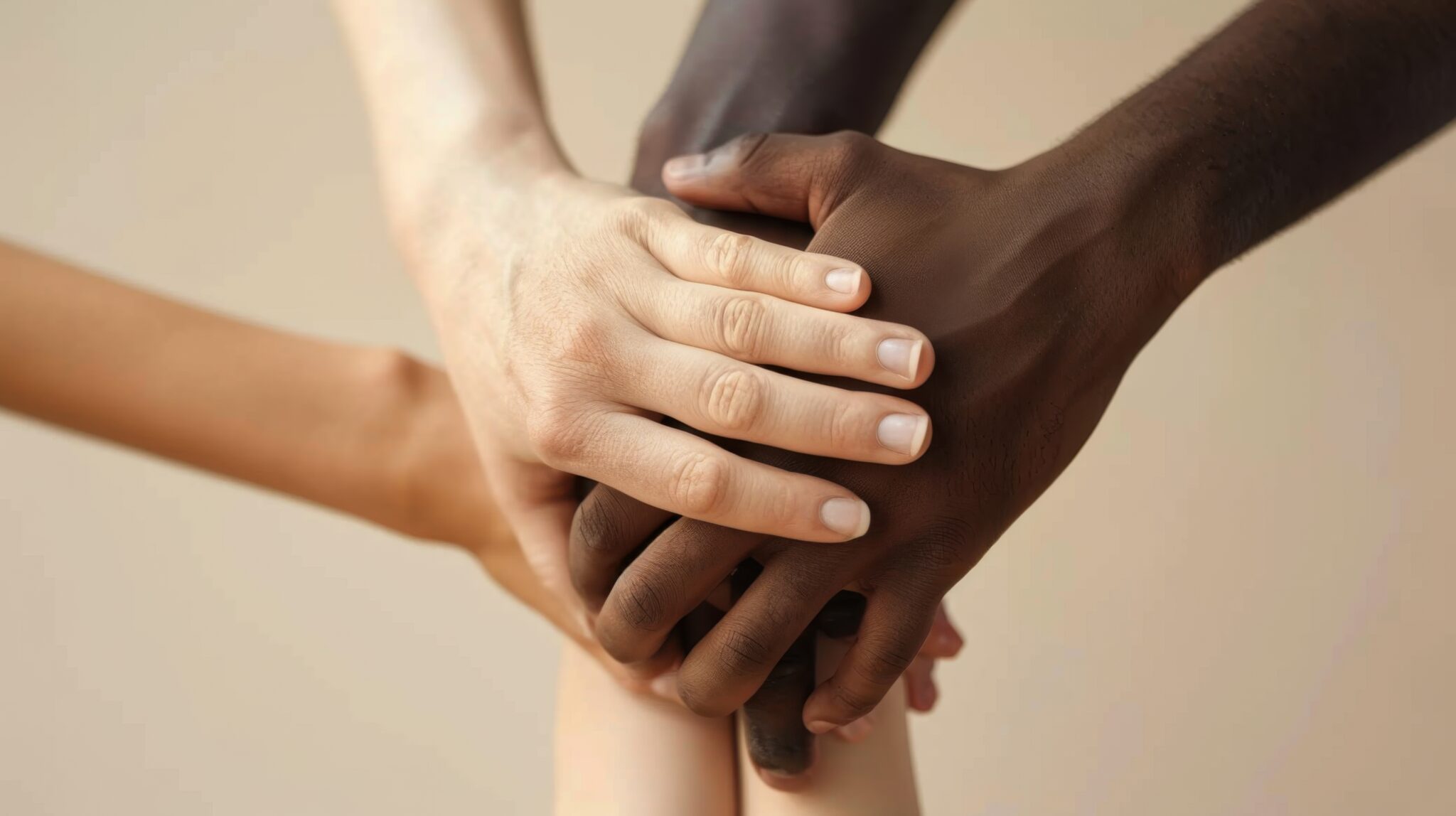 A closeup of diverse hands joined together, symbolizing unity, support, and inclusivity across different communities and backgrounds