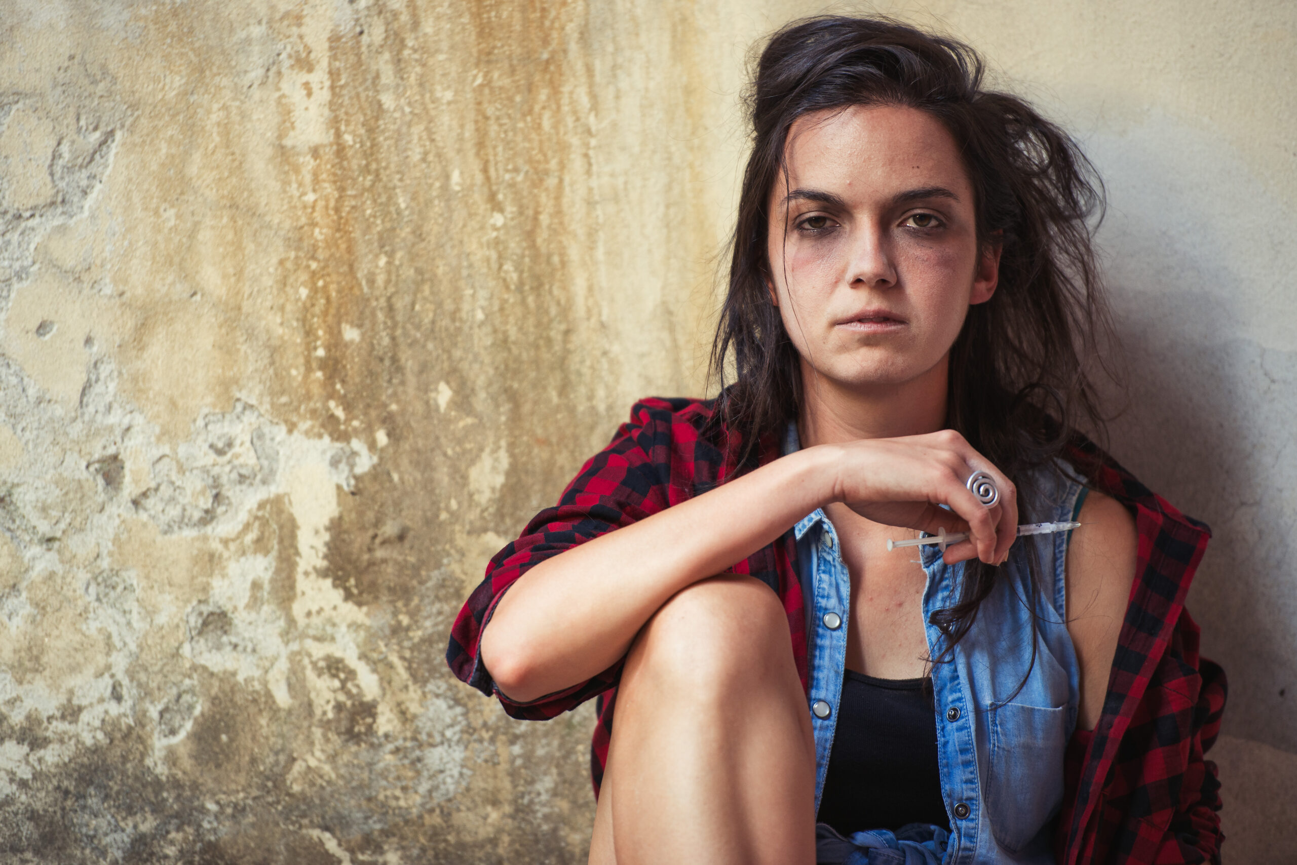 Dependence on drug heroin young woman after having pierced with syringe.